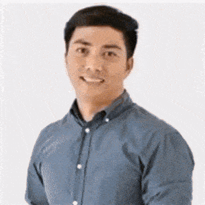a man in a blue shirt is smiling and looking at the camera