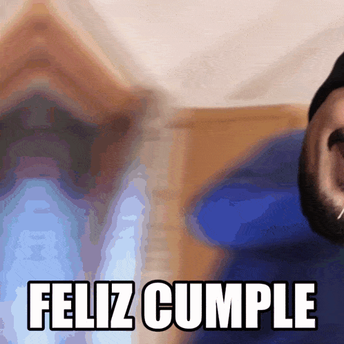 a man with a beard says feliz cumple in front of his face