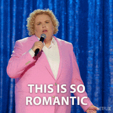 a woman in a pink suit is holding a microphone and the caption says this is so romantic