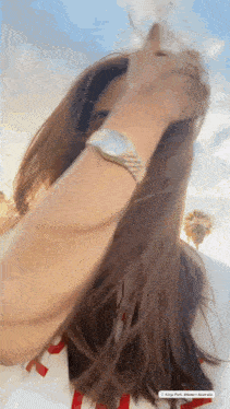 a woman with long hair is wearing a watch on her wrist ..