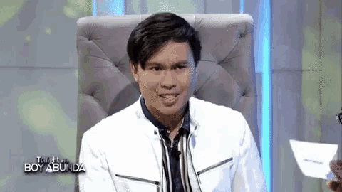 a man is sitting in a chair with a card in his hand .