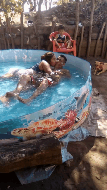 a man and a woman are kissing in a pool with a dolphin design