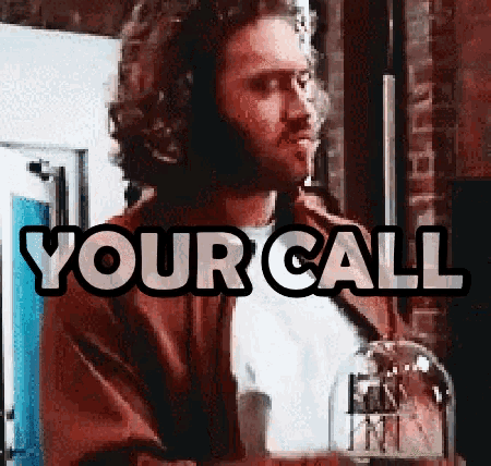 a man with a beard stands in front of a sign that reads your call