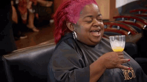 a woman with red hair is holding a glass of orange juice