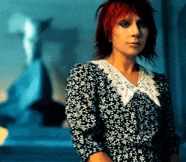 a woman with red hair and a black and white dress