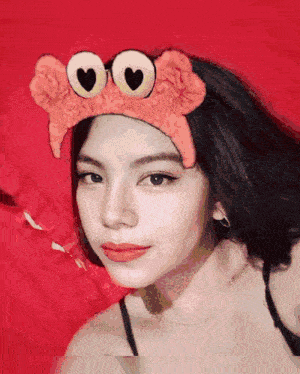 a girl wearing a headband that looks like a crab with hearts on the eyes