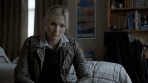 a woman in a leather jacket is sitting on a bed and says " sounds logical "