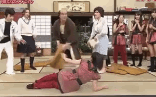 a group of people are standing around a person on the floor .