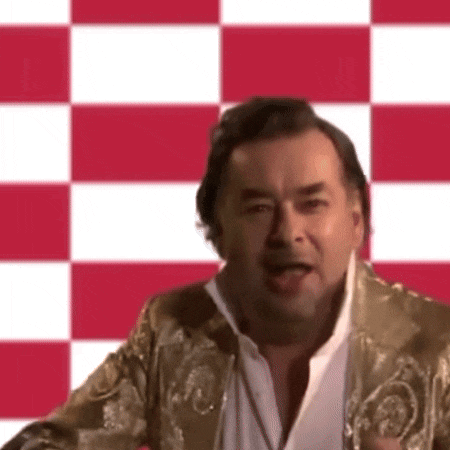 a man wearing a gold jacket and white shirt is standing in front of a checkered background .
