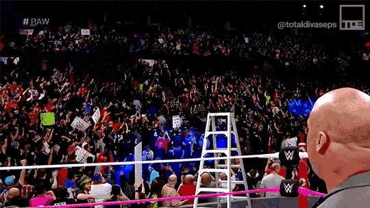 a man is standing in front of a crowd of people in a stadium .