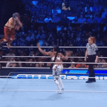 a wrestler is jumping over another wrestler in a ring
