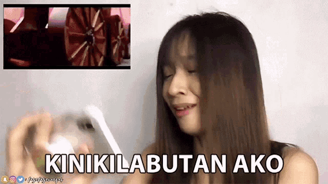 a woman holding a cell phone with the words " kinikilabutan ako " written on the bottom