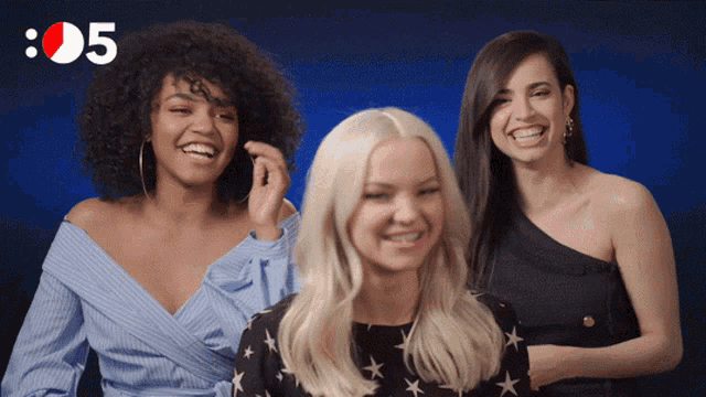 three women are smiling in front of a blue background with the number 8:05