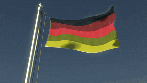a german flag flies in the wind against a blue sky