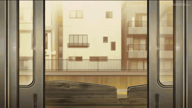 a view of a city from the inside of a train with an anime.com logo in the corner