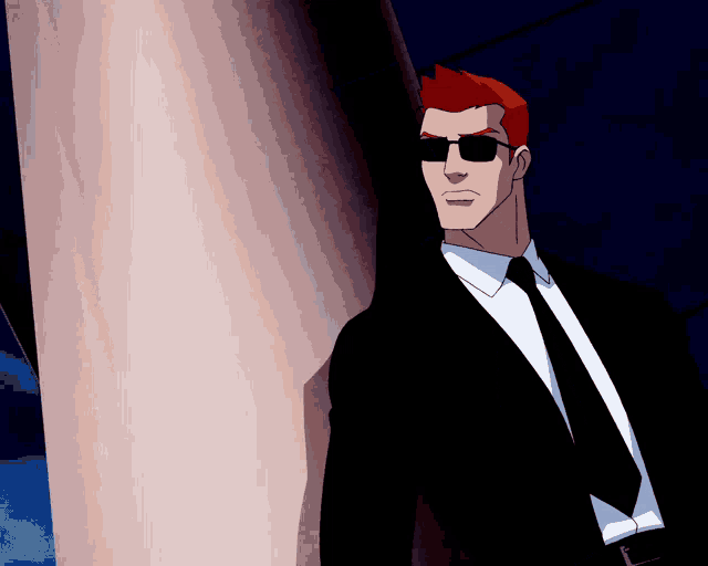 a man in a suit and tie leaning against a wall