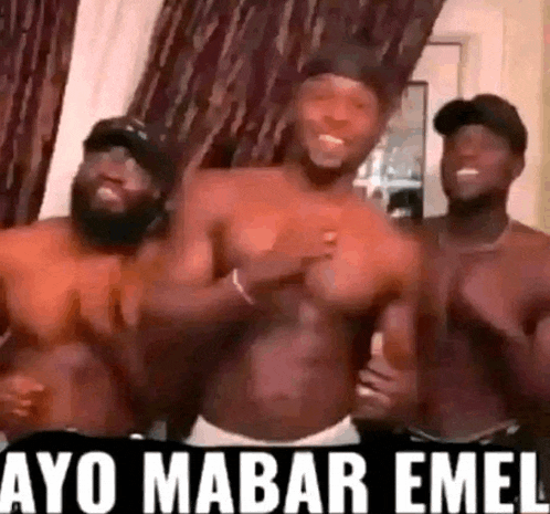 a group of shirtless men are standing next to each other and dancing .