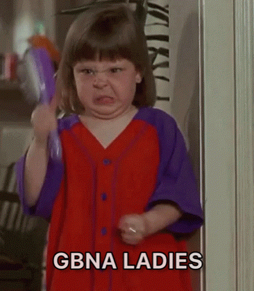 a little girl in a red and purple dress is holding a comb and making a funny face .