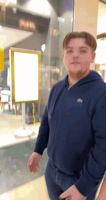 a man wearing a blue jacket with a lacoste logo