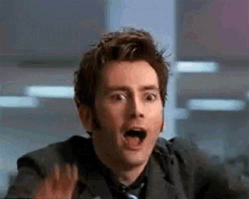 a man in a suit and tie is making a funny face .