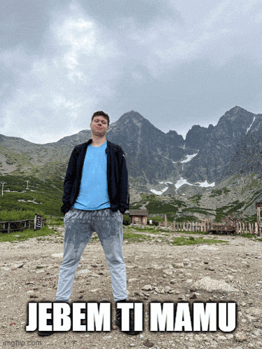 a man standing in front of a mountain with the words jebem ti mamu