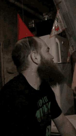 a man with a beard wearing a party hat and a shirt that says i pick ugly