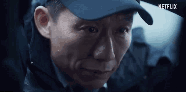 a close up of a man 's face wearing a hat and a jacket .
