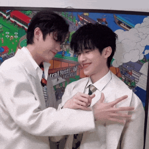 two men are hugging each other in front of a poster that says festival eastville