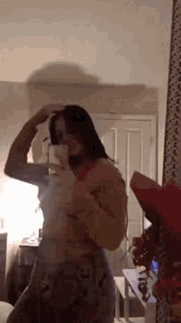 a girl is taking a selfie in front of a mirror .