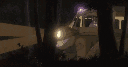 a bus is driving through the woods at night .