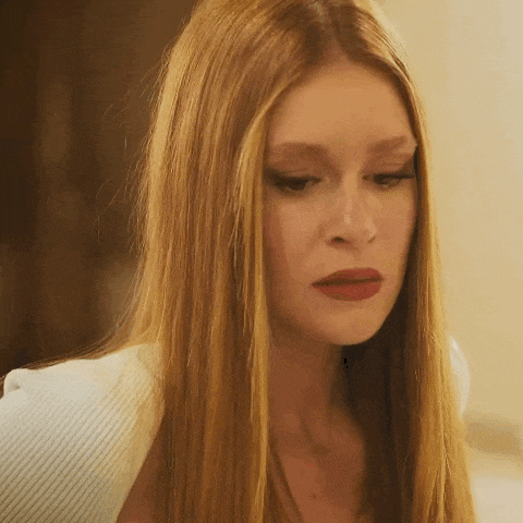 a woman with long red hair is wearing a white shirt