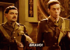 two men in military uniforms are standing next to each other and one of them is saying bravo .