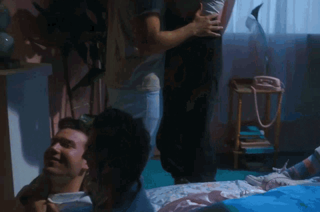 a man is holding a woman in his arms in a bedroom