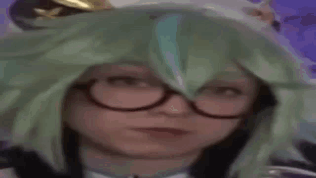 a woman wearing a green wig and glasses is making a funny face .