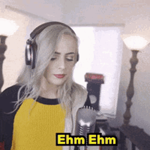 a woman wearing headphones is singing into a microphone with the name ehm ehm written on the bottom