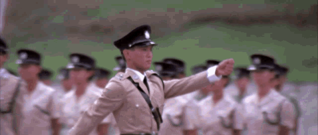 a man in a military uniform is standing in front of a group of people