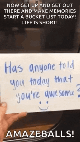 a person is holding a piece of paper with a smiley face on it .
