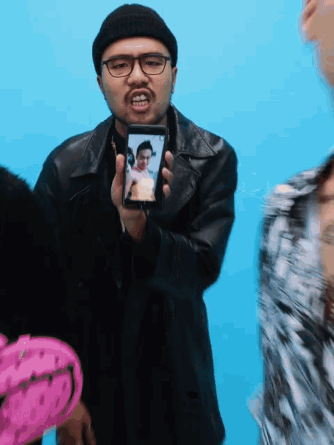a man holding a cell phone with a picture of a man on it