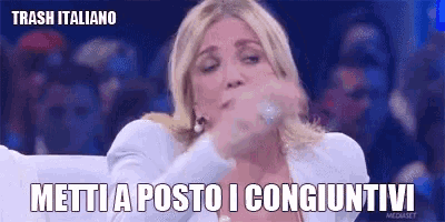a woman in a white jacket is making a funny face with the words trash italiano written above her .