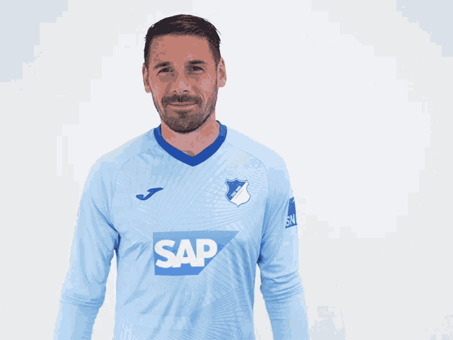 a man wearing a blue shirt and a pair of gloves that says uhlsport