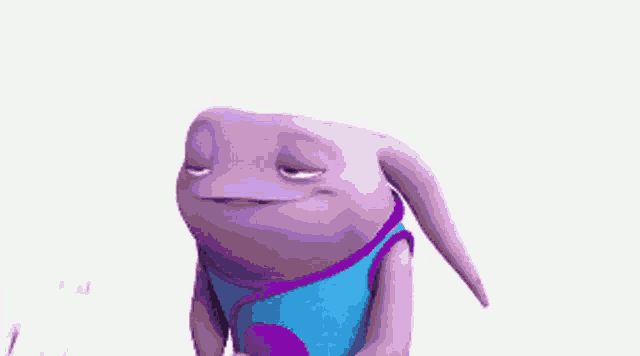 a purple cartoon character with a blue shirt is standing on a white surface .