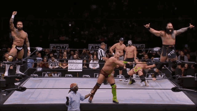 a group of wrestlers are standing in a ring with a sign that says aew