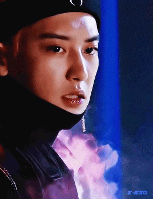 a close up of a person 's face with a x-exo logo in the corner