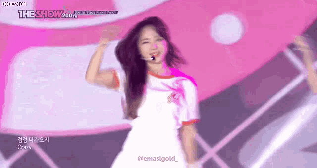 a girl is dancing on a stage with a microphone in her mouth .