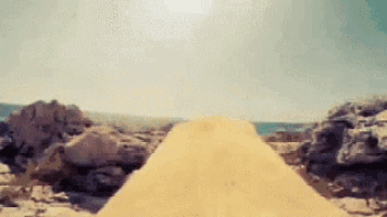a person is standing in the sand near a pile of sand .