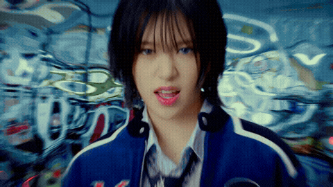 a girl with short hair is wearing a blue jacket and tie with the letter s on it