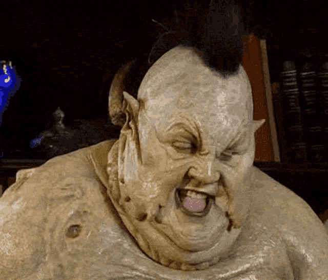a statue of a monster with horns and a mohawk has his tongue hanging out