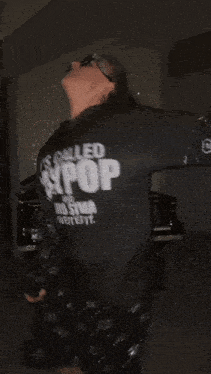 a woman wearing a black shirt that says allec pop on it