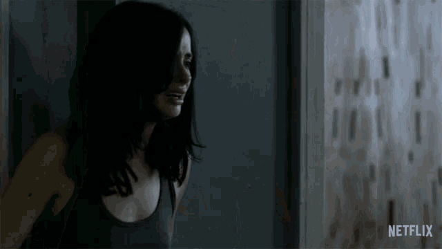 a woman is standing in a dark room with a netflix logo behind her