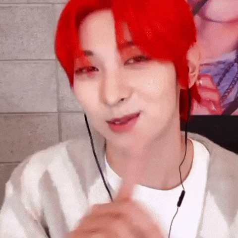 a man with red hair is wearing headphones and making a face .